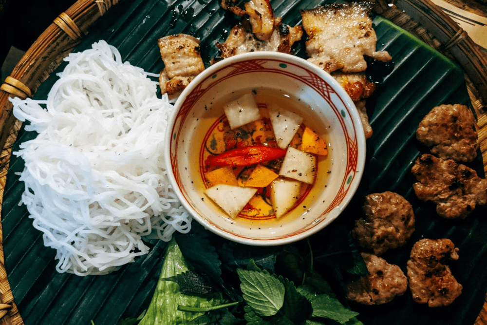 Bun Cha Hanoi consists of aromatic grilled pork, fresh vermicelli noodles, herbs, and a tangy-sweet dipping sauce (Source: Pexels)