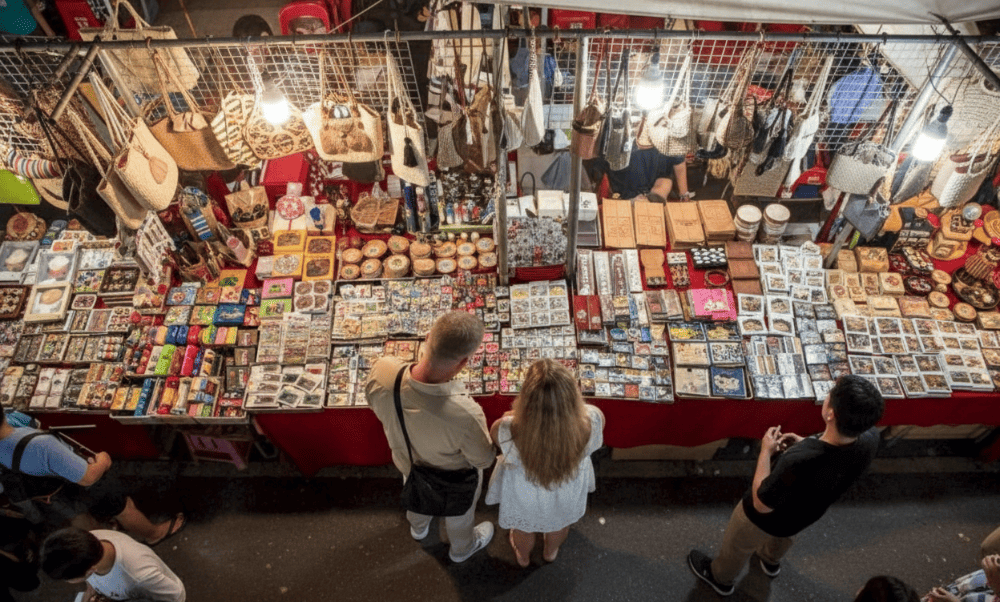 Western tourists enjoy shopping at the night market in Hanoi