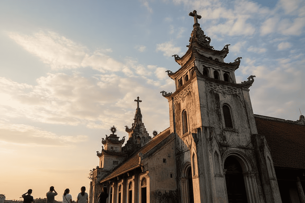 The tower's roof, with curved tiles and a cross symbol, blends Gothic and Vietnamese architectural