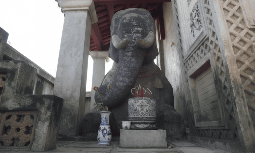 Two kneeling stone elephants guard the entrance, giving the temple its name, 'Voi Phuc’